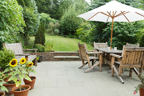 Natural tone stone patio with wooden garden furniture